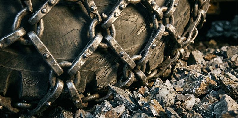 Close-up of our WJ-2 LHD's heavy-duty tire with metal protection chain, operating in a rugged underground mine, showcasing extreme durability. Close-up of our WJ-2 LHD's heavy-duty tire with metal protection chain, operating in a rugged underground mine, showcasing extreme durability.