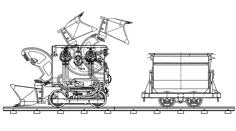 Pneumatic rock loader on rail tracks inside a narrow underground mine tunnel