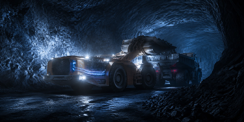 Cover image for the article "Overcoming the Andes" featuring a massive yellow mining dump truck climbing a rocky high‑altitude road in the Andes with bold uppercase text "THIN AIR" stacked above "HEAVY LIFTING" overlaid in the sky.