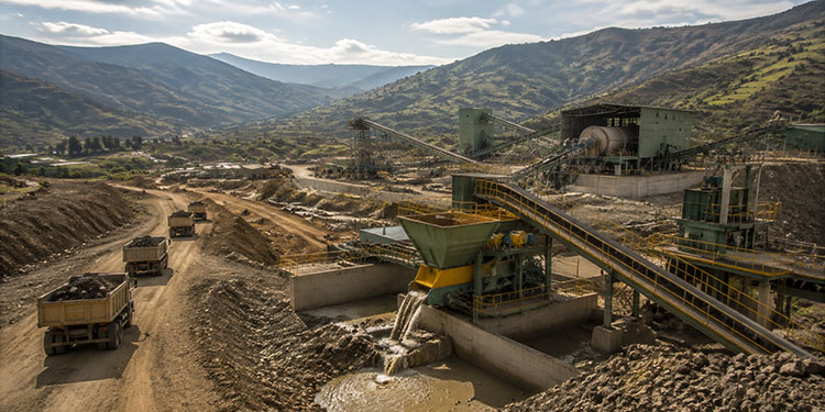 Close-up industrial illustration of a massive ball mill gear and manganese steel liner blending into an abstract map of Ethiopia, set against a golden highland landscape at dawn.