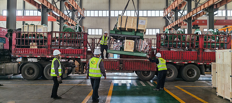 Factory crane loading JTK mining hoist onto truck for Africa shipment.