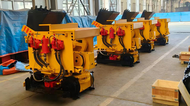 Five ZQ-15 pneumatic rock loaders wrapped in blue tarpaulins and secured with orange straps inside a 40ft high-cube container for sea shipment. Five ZQ-15 pneumatic rock loaders wrapped in blue tarpaulins and secured with orange straps inside a 40ft high-cube container for sea shipment.