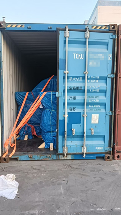 Five ZQ-15 pneumatic rock loaders wrapped in blue tarpaulins and secured with orange straps inside a 40ft high-cube container for sea shipment. Five ZQ-15 pneumatic rock loaders wrapped in blue tarpaulins and secured with orange straps inside a 40ft high-cube container for sea shipment.