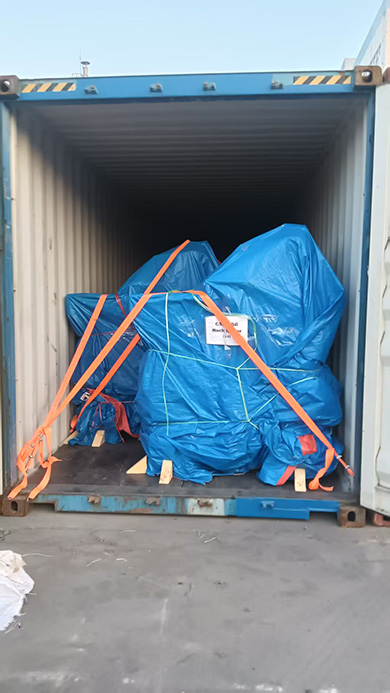 Five ZQ-15 pneumatic rock loaders wrapped in blue tarpaulins and secured with orange straps inside a 40ft high-cube container for sea shipment.
